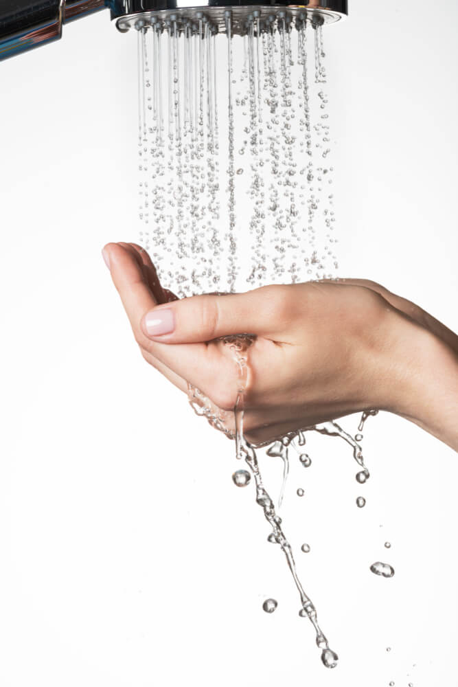 closeup-female-hands-stream-splashing-water-skin-care-concept 5 Easy Ways to Create an Eco-Friendly Bathroom - 2